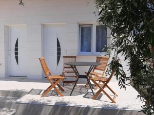 un patio con mesa y 2 sillas en Apartmani Benjamin, en Bibinje