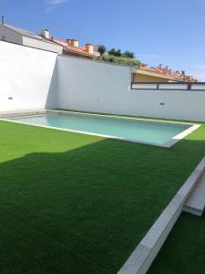 una piscina al lado de un edificio con césped verde en Lavra Beach House, en Lavra