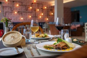 a table with a plate of food and glasses of wine at Aqua Natura Bay in Porto Moniz