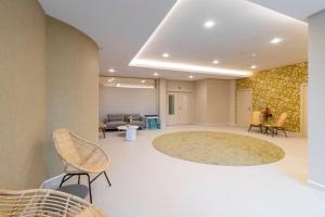 a lobby with chairs and a large rug at Aqua Natura Bay in Porto Moniz