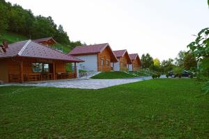 a row of wooden houses in a field of grass at Sherwood resort in Bihać
