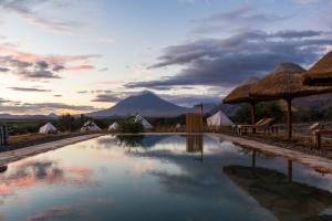 a pool at a resort with a mountain in the background at Africa Safari Lake Natron Camping in Mtowabaga