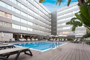un hotel con piscina con sillas y un edificio en Hotel & Spa Villa Olimpica Suites en Barcelona