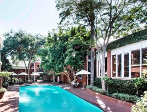 uma piscina em frente a uma casa em Premier Hotel Falstaff em Joanesburgo