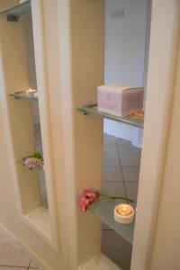 
a shelf with a mirror and candles on it at AHG Donna Silvia Hotel Wellness & SPA in Manerba del Garda

