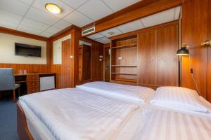 a bedroom with a large bed with wooden walls and a desk at Grand Jules - Boat Hotel in Budapest