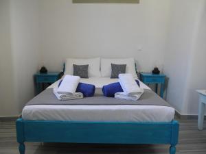 a blue and white bed with blue pillows on it at Era Tefra in Éxo Goniá