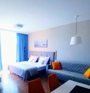 een hotelkamer met een bed en een bank bij Bel Mare Wyspa, apartament z parkingiem gratis in Międzyzdroje