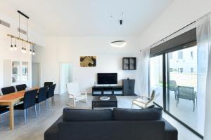 sala de estar con sofá y mesa en Luxury Living at Achziv Beach Apartment by Sea N' Rent, en Nahariyya