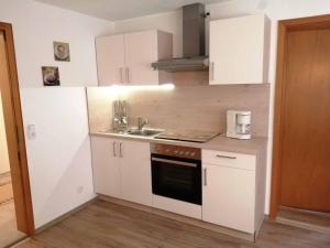 a small kitchen with white cabinets and a sink at Ferienwohnungen Berger in Lam