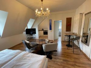 una camera con letto e un soggiorno con lampadario a braccio di FEWO Schlossberg Weingut C.A. Haussmann a Traben-Trarbach