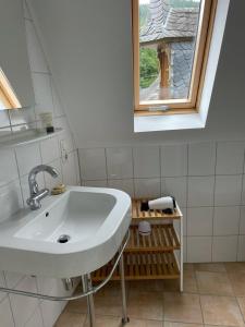 un lavandino bianco in un bagno con finestra di FEWO Schlossberg Weingut C.A. Haussmann a Traben-Trarbach
