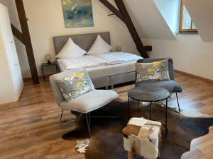 una camera con un letto e due sedie di FEWO Schlossberg Weingut C.A. Haussmann a Traben-Trarbach