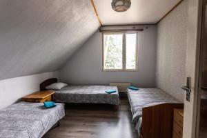 two beds in a room with a window at LAKE HOUSE in Rīga