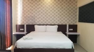 sypialnia z łóżkiem z dwoma ręcznikami w obiekcie Jember City Hotel w mieście Jember