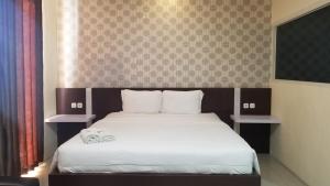 Postel nebo postele na pokoji v ubytování Jember City Hotel