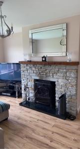 sala de estar con chimenea de piedra y espejo en Modern Home Carndonagh, en Carndonagh