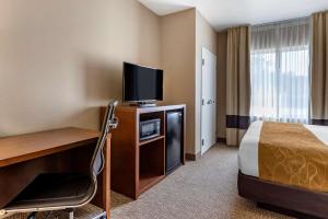 a hotel room with a bed, desk and television at Comfort Suites Coralville I-80 in Coralville