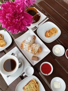 uma mesa com pratos de pastelaria e chávenas de café em Hotel Aristokrat em Ufa