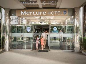 een groep mensen die een metrohotel uitlopen bij Hotel Mercure Alger Aéroport in Dar el Beïda