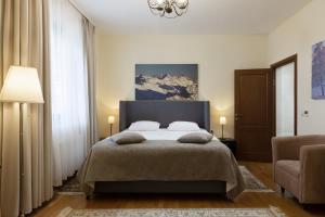 a bedroom with a large bed and a chair at Rosa Chalet Rosa Khutor in Estosadok
