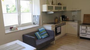 a living room with a couch and a kitchen at Ferienwohnungen Wassertheurer - Weitendorf in Sankt Kanzian