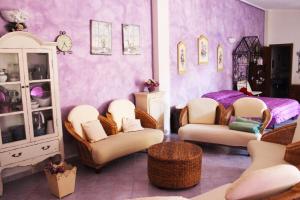 una camera con sedie e una camera da letto con pareti viola di Villa Marina a Orosei