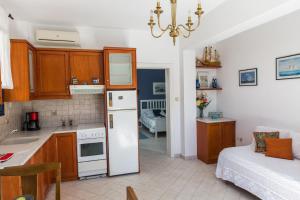 a kitchen with a white refrigerator freezer in a room at Villa Euphoria Studio in Aegina, A' Marathonas Bay in Egina