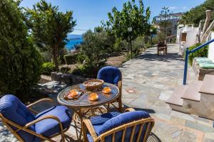 a patio with a table and chairs and the ocean at Villa Euphoria Studio in Aegina, A' Marathonas Bay in Egina