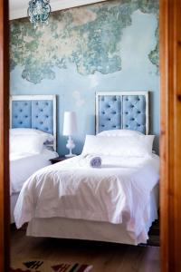 een slaapkamer met 2 bedden en een kaart aan de muur bij Courchevel Cottages in Franschhoek