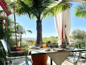 einen Tisch mit Stühlen und eine Palme auf der Terrasse in der Unterkunft Best Luxury Boutique B&B Vista do Vale Tomar in Tomar