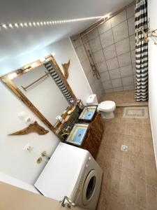 La salle de bains est pourvue d'un lavabo et de toilettes avec un miroir. dans l'établissement Village Villa Marika - Mimis Drapanias, à Dhrapaniás