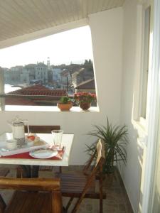 una mesa y una silla en un balcón con ventana en Apartments Benutic-Lalini, en Kaštela