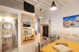 a bedroom with a bed and a sink and a mirror at Archipelagos Kimolos in Kimolos
