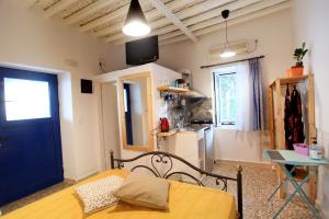 a room with a bed and a table and a kitchen at Archipelagos Kimolos in Kimolos