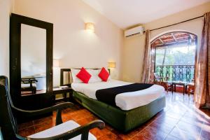 a bedroom with a bed with a mirror and a window at Sea Breeze Beach, Calangute, Goa in Calangute