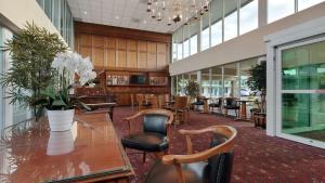 a lobby with a glass table and some chairs and tables at SureStay Plus Hotel by Best Western Brandywine Valley in Wilmington