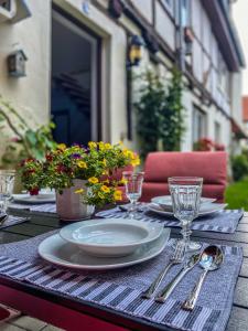 een tafel met borden, glazen en bloemen erop bij Am Mathildenbrunnen groß in Quedlinburg