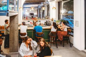 un grupo de personas sentadas en un bar en Athens Backpackers, en Atenas