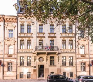 un grand bâtiment avec des voitures garées devant lui dans l'établissement Liebeskind Boutique Hotel, à Cracovie