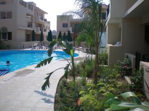 a swimming pool in front of a building at 104 Excellent 2 bed apartment with pool view, AC & gym! in Perivolia