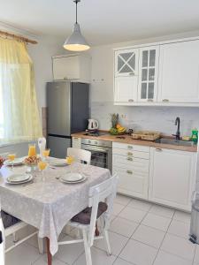 a white kitchen with a table and a refrigerator at Apartment Silvana II in Šibenik