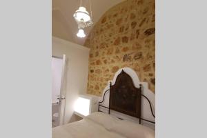 ein Schlafzimmer mit einem Bett und einer Steinmauer in der Unterkunft Dimora di charme Corte della Torre Salento in Morciano di Leuca