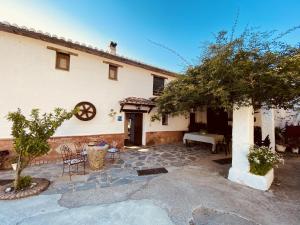 a house with a table and chairs in front of it at Finca El Molino De Aceite in Jubrique