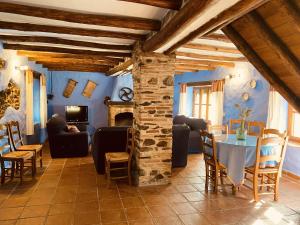 a living room with a table and a stone pillar at Finca El Molino De Aceite in Jubrique