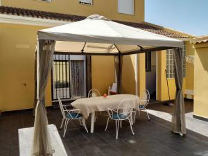 - une table et des chaises sous une tente sur une terrasse dans l'établissement Beautiful House Sierrecilla, à Humilladero