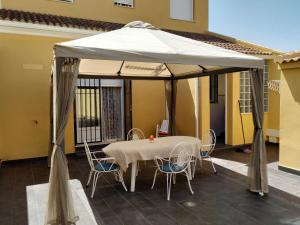 a table and chairs under a tent on a patio at Beautiful House Sierrecilla in Humilladero