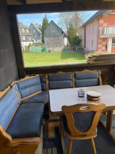 ReichenbachにあるHaus Zauberwaldのテーブルと椅子、窓が備わる客室です。