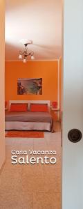 1 dormitorio con 1 cama con pared de color naranja en Casa vacanze Salento en Diso