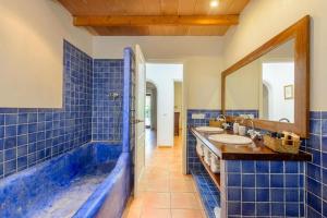 a blue tiled bathroom with two sinks and a mirror at Villa Rosa in Sant Josep de sa Talaia +27 photos